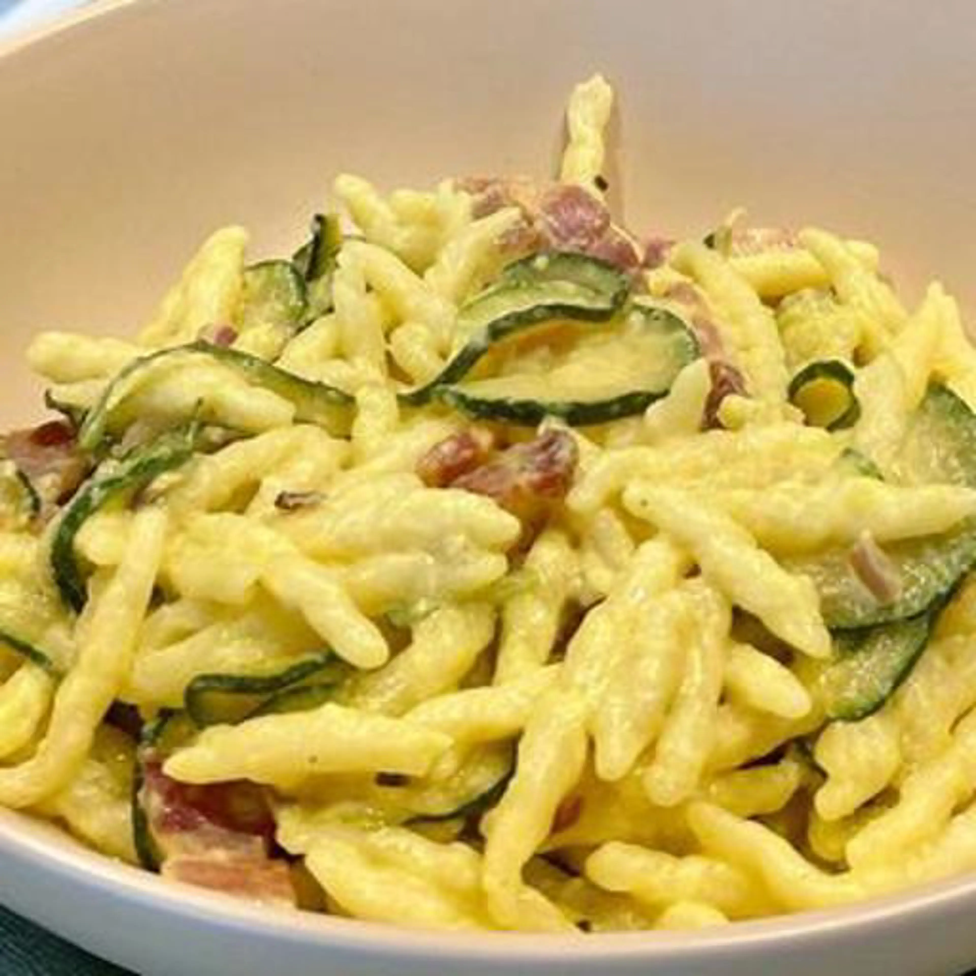 Trofie com creme de robiola e açafrão, bacon e courgettes