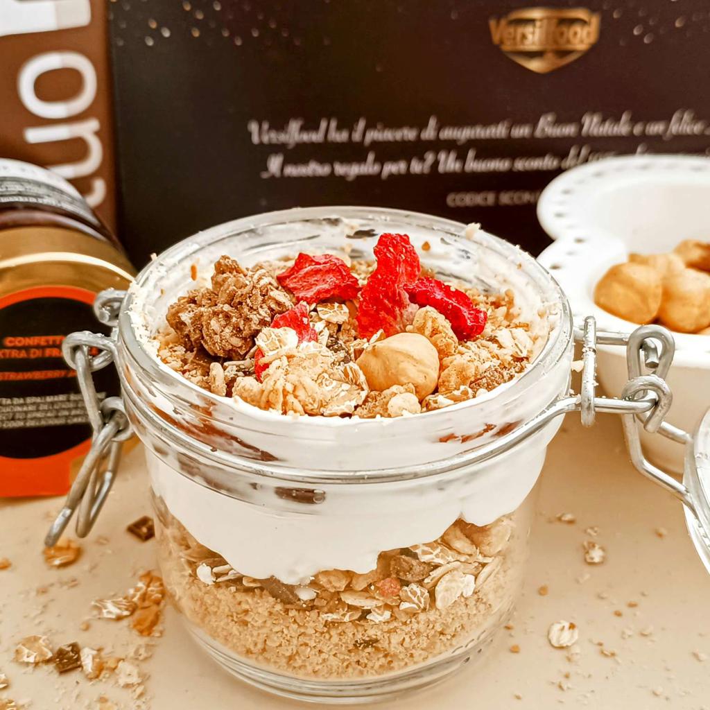 Ontbijt in een pot met toast, hazelnoten, yoghurt en jam