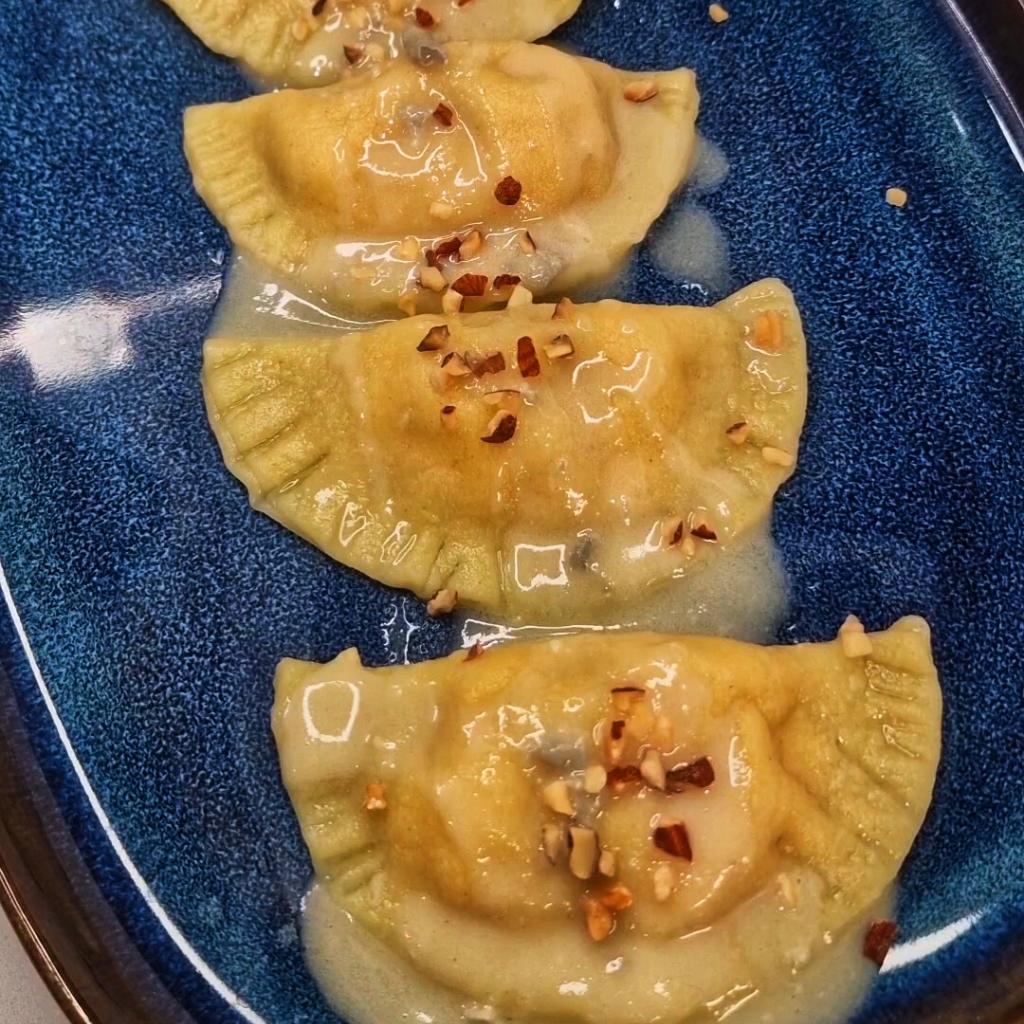Mezzelune van pompoen met gorgonzola-fondue en geroosterde amandelkruim